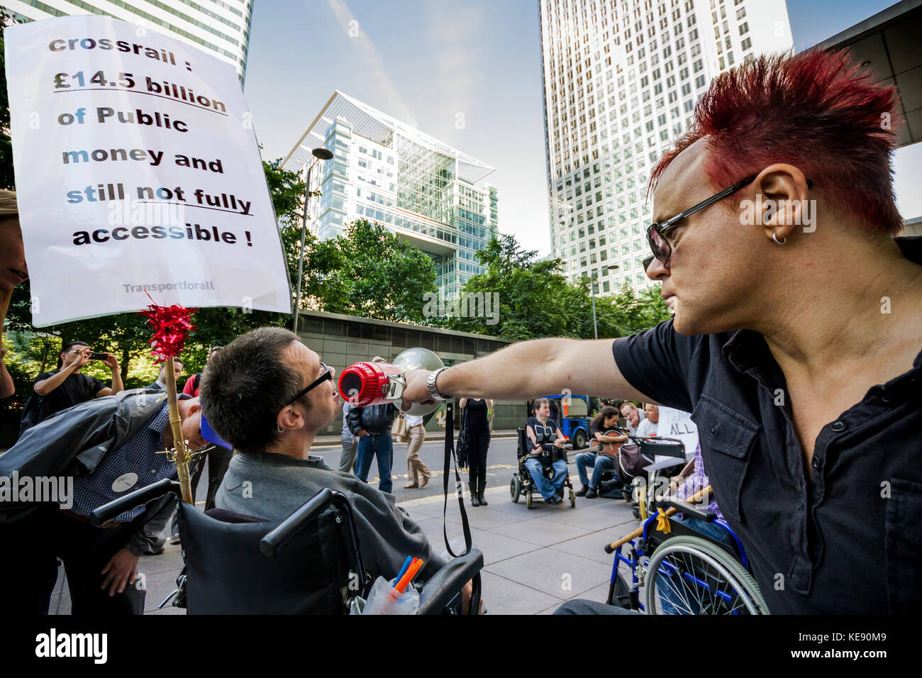 Activistas de discapacidad protesta fuera del edificio de la oficina de cabeza el travesaño en Canary Wharf, Londres, Reino Unido. Foto de stock