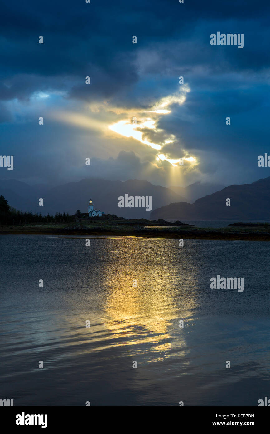 Luz del amanecer espectacular y rayos de sol en Ornsay faro sobre el islote de Eilean Sleat Sionnach fuera de la península, la Isla de Skye, Highland, Scotland, Reino Unido Foto de stock