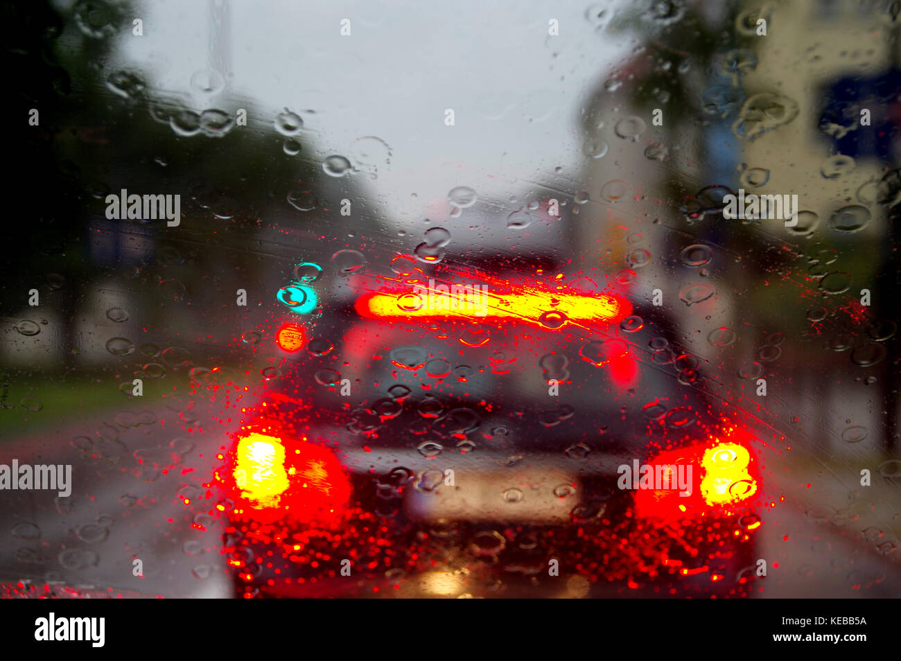 Gotas de agua en el coche de cristal. desenfoque bokeh y las luces de la calle detrás. Foto de stock