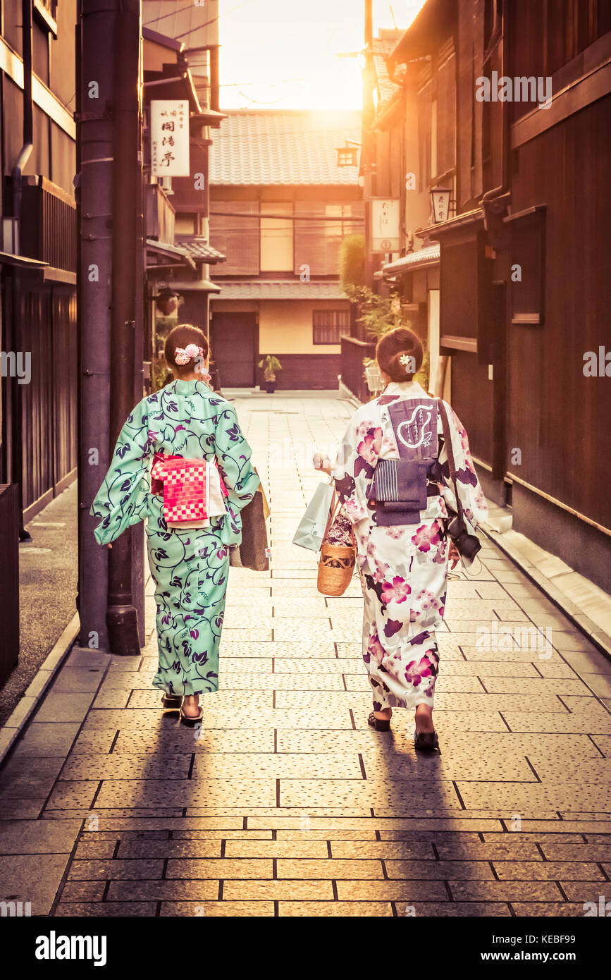 Dos señoras viste kimonos japoneses a pie a su casa al atardecer en Gion, Kioto Foto de stock