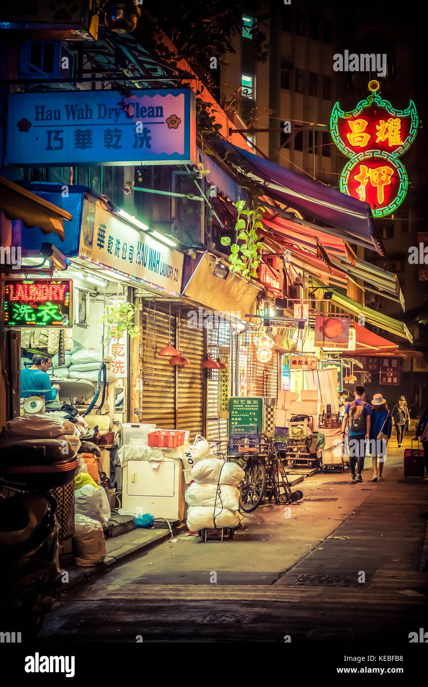Una lavandería sigue trabajando mucho después de que el mercado está cerrado por la noche en Wan Chai, Hong Kong Foto de stock