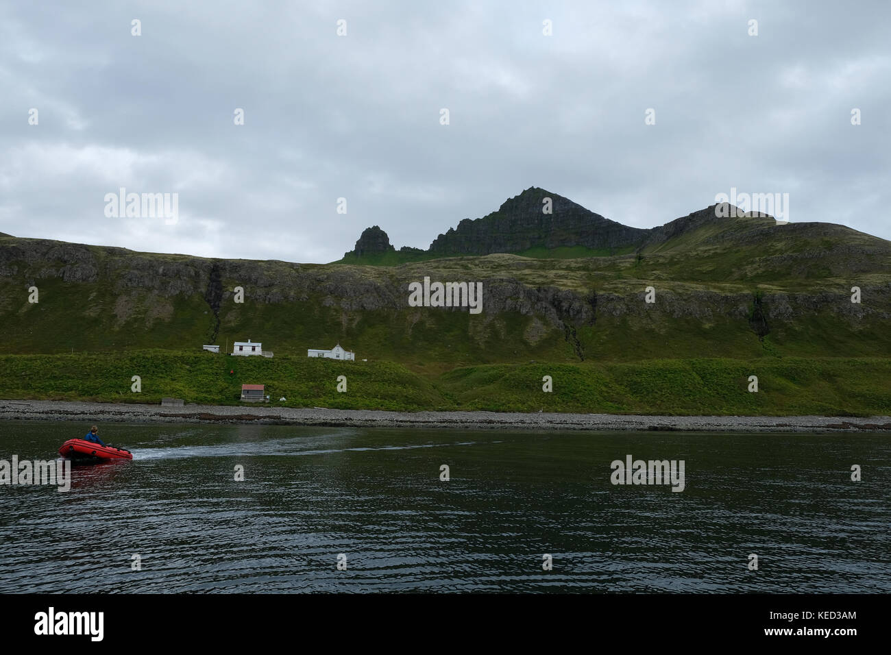 La vista horizontal de zodiac transportar turistas a casas de vacaciones en la reserva natural de hornstrandir westfjords, Islandia Foto de stock
