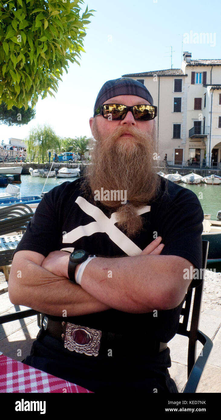 MAnn mit langem Bart und Sonnenbrille am Gardasee bei Descenzano Foto de stock