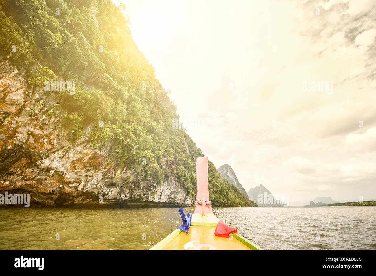 Un bote de cola larga es la vela en el Ao Phang Nga (Phang Nga Bay) Parque Nacional al atardecer. La bahía de Phang Nga es una de las provincias del sur de Tailandia (changwat) Foto de stock