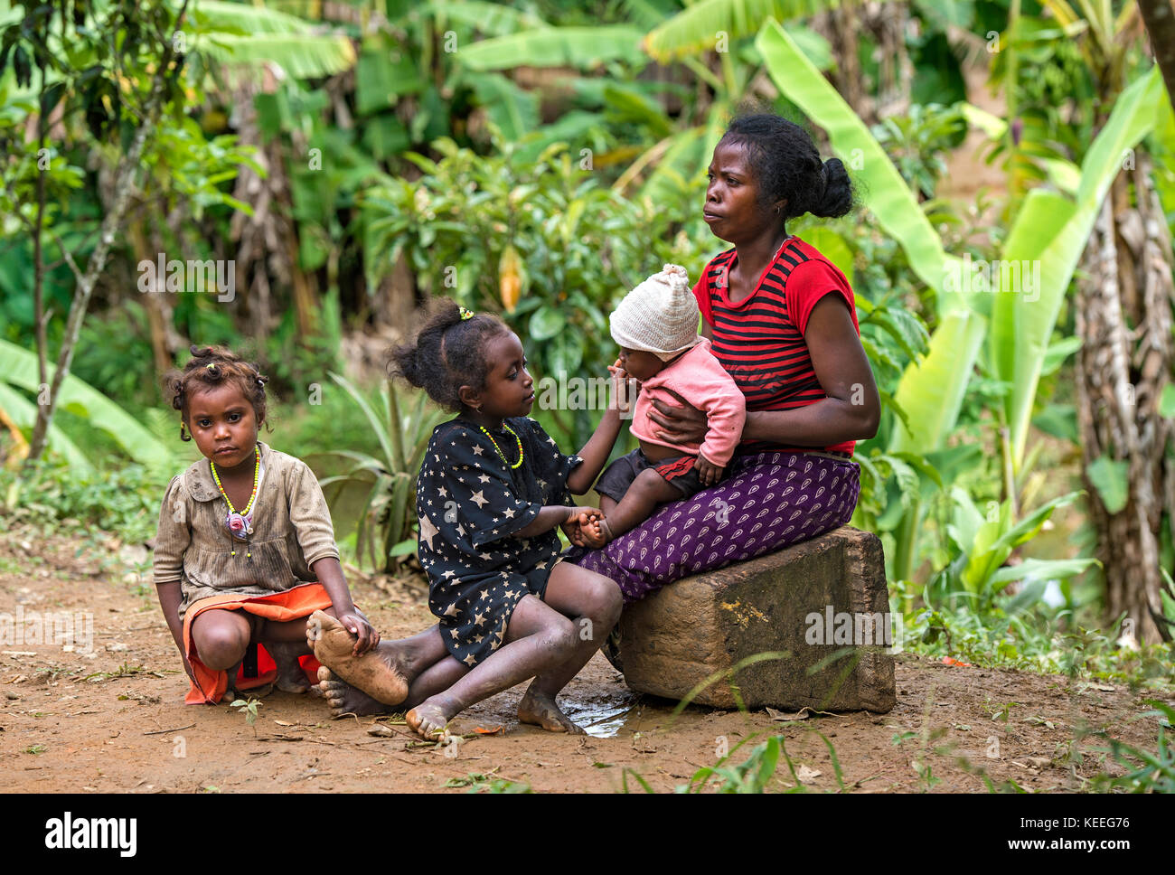 Madre con sus tres hijos del grupo étnico de los betsimisaraka en la costa oriental de Madagascar, ambavaniasy, Madagascar Foto de stock