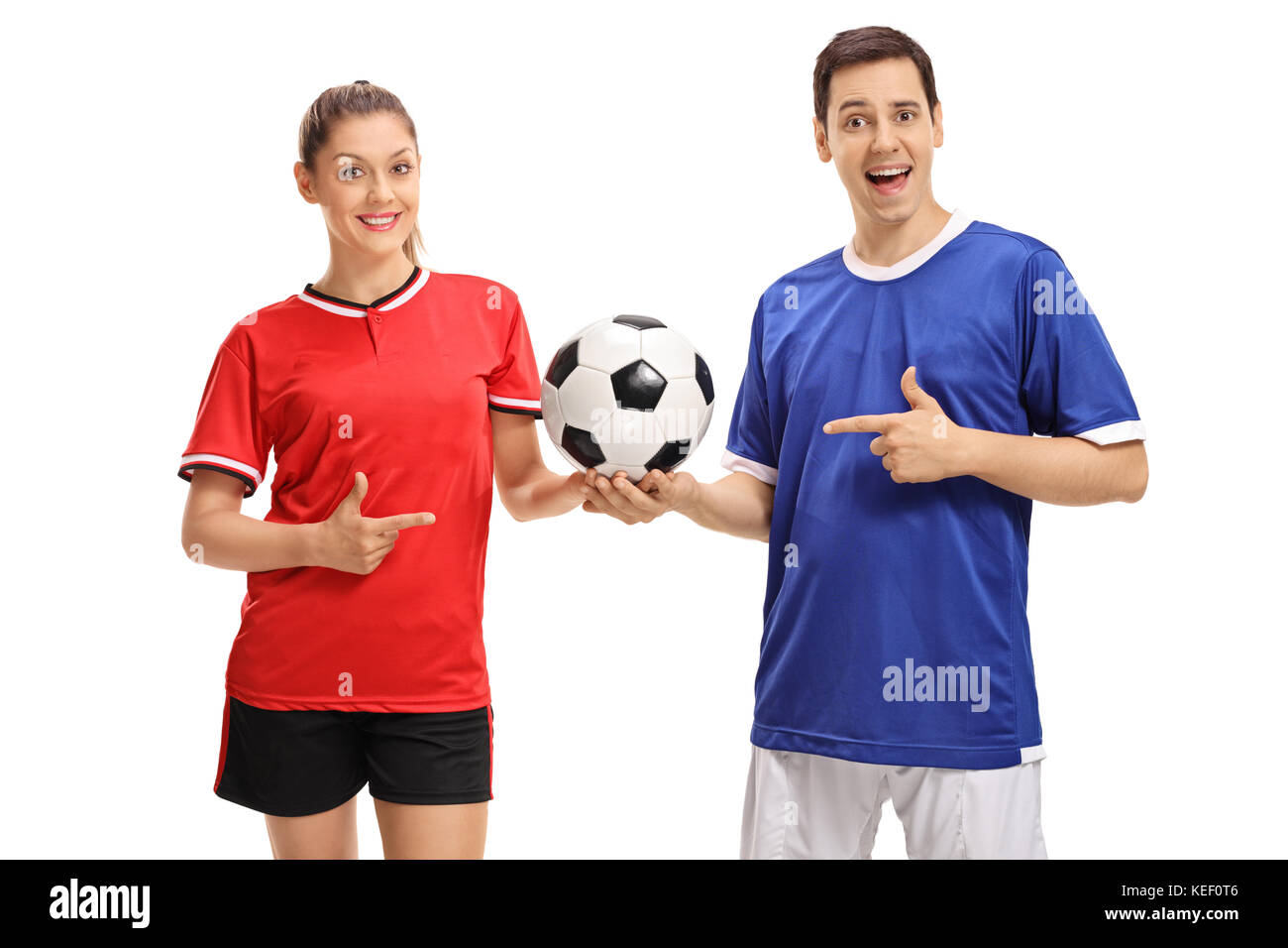Futbolista hembra y un macho futbolista sosteniendo un fútbol y apuntando aislado sobre fondo blanco. Foto de stock