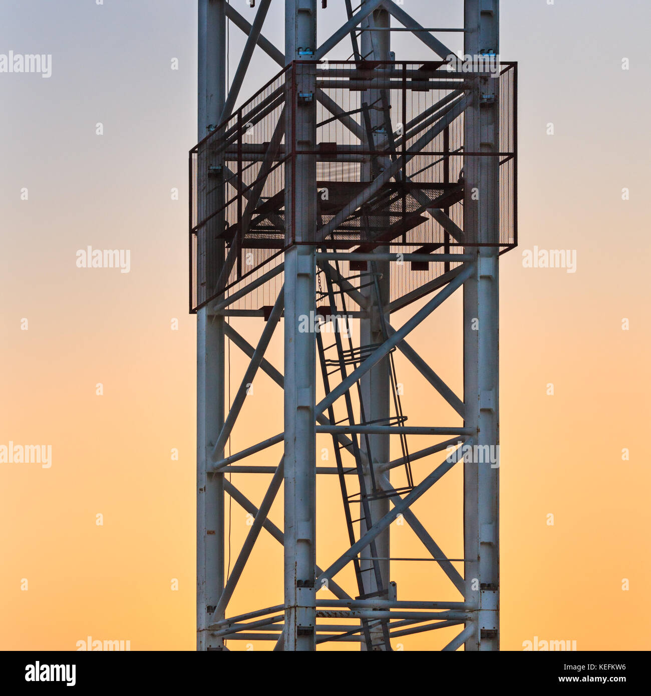 Detalle del mástil de la grúa de la torre disparado contra el cielo del atardecer Foto de stock