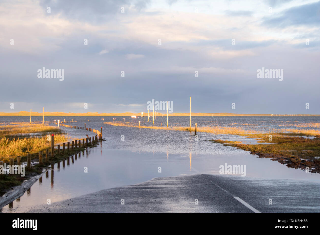 Por la tarde la luz sobre Lindisfarne o Holy Island causeway de marea en marea alta mirando hacia de Lindisfarne, en Northumberland, Inglaterra, Reino Unido. Foto de stock