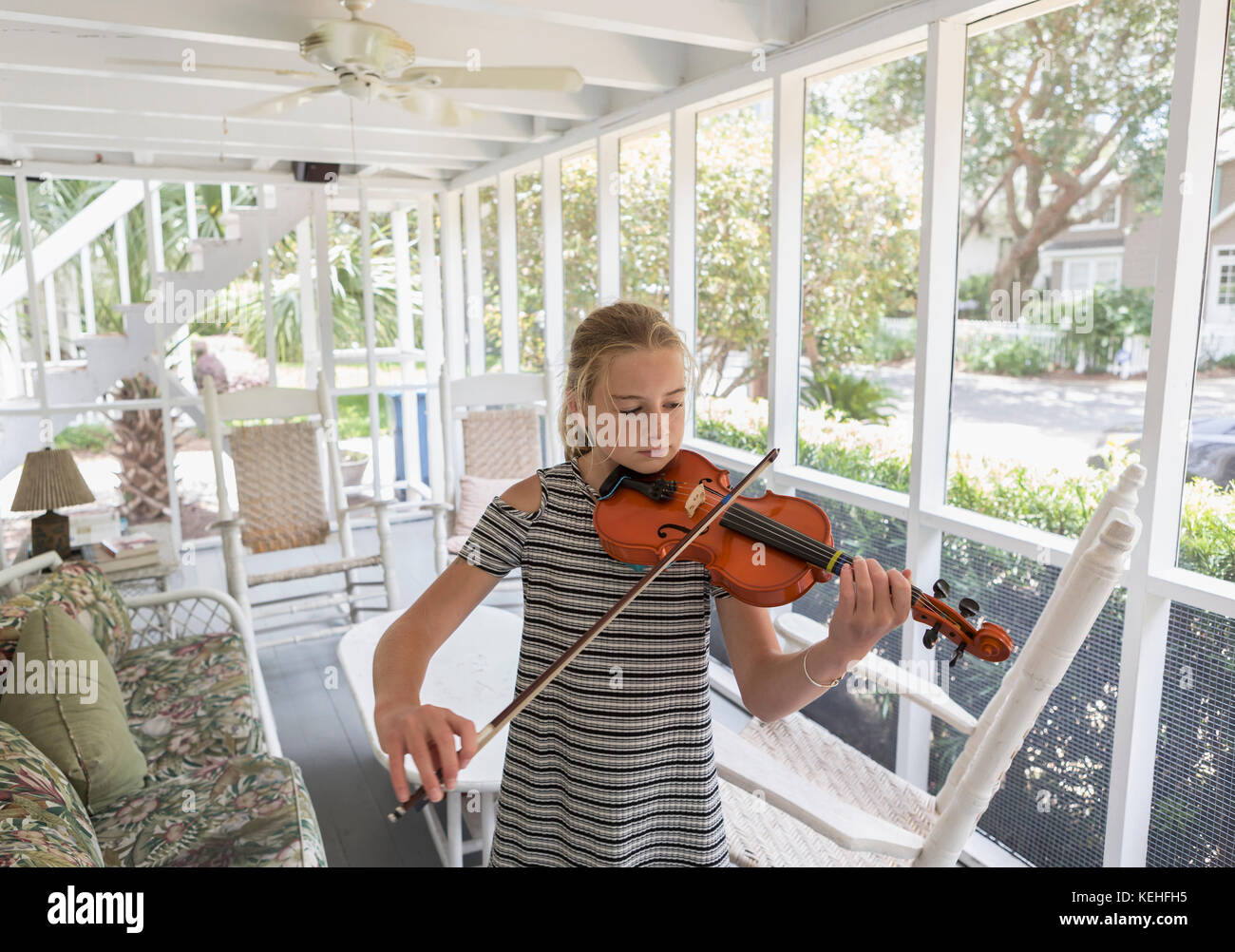Una chica caucásica tocando violín en el patio Foto de stock