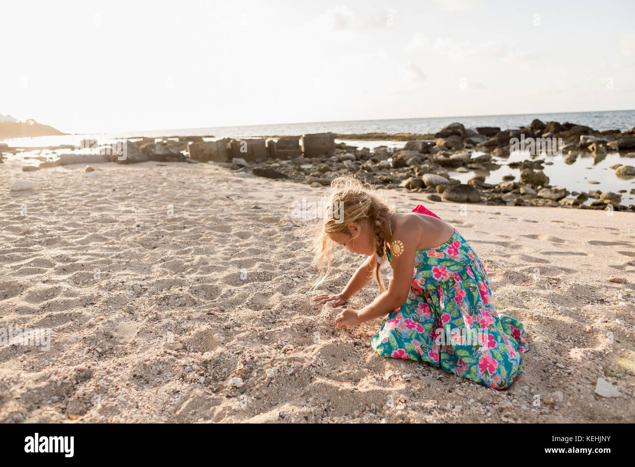 Chica caucásica jugando en la arena en la playa Foto de stock