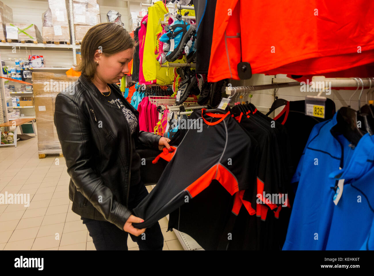 Mujer caucásica examinando la camisa en la tienda Foto de stock