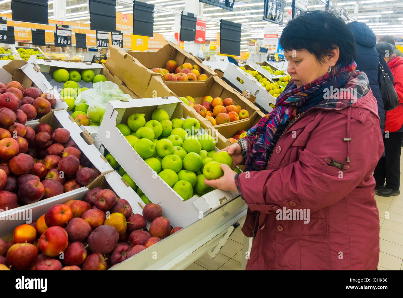 Mujer caucásica examinando manzanas Foto de stock