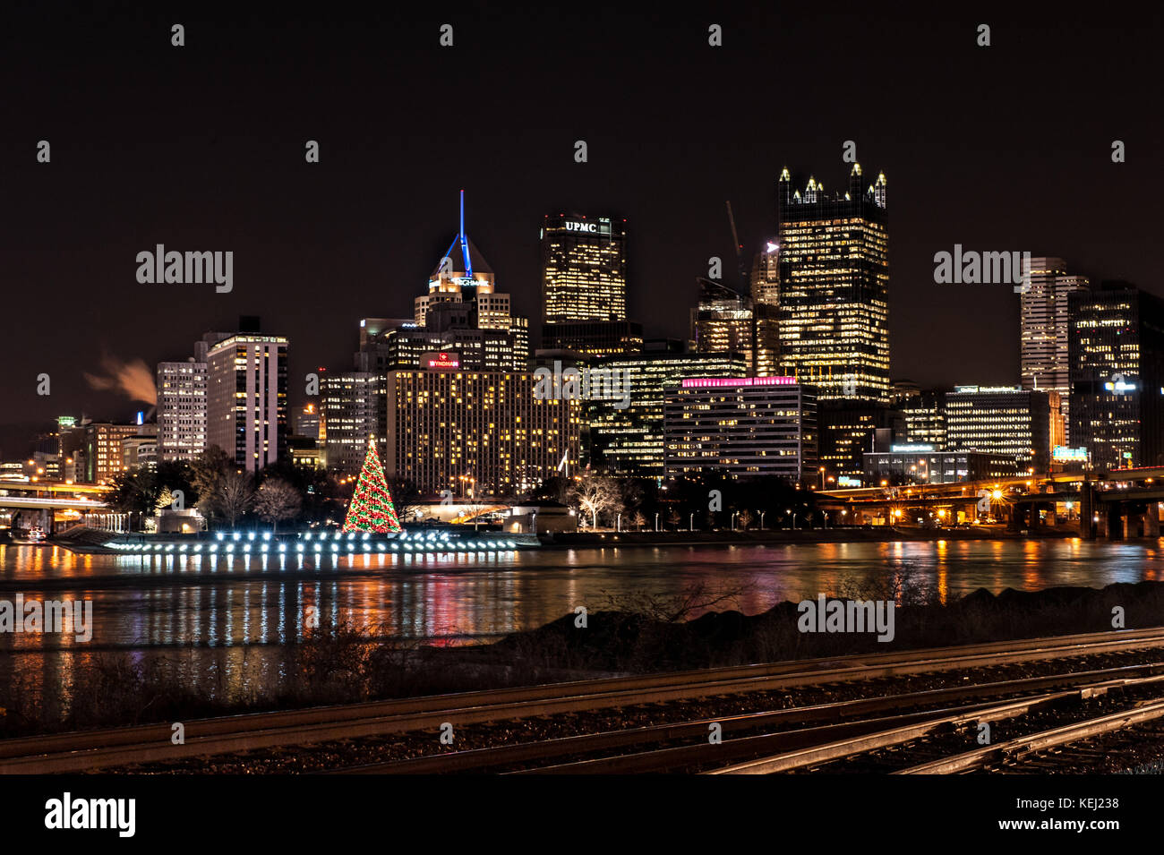 Pittsburgh horizonte se iluminan durante la noche, varios rascacielos, árbol de navidad y el río allegheny waterfront en Pennsylvania, EE.UU. Foto de stock