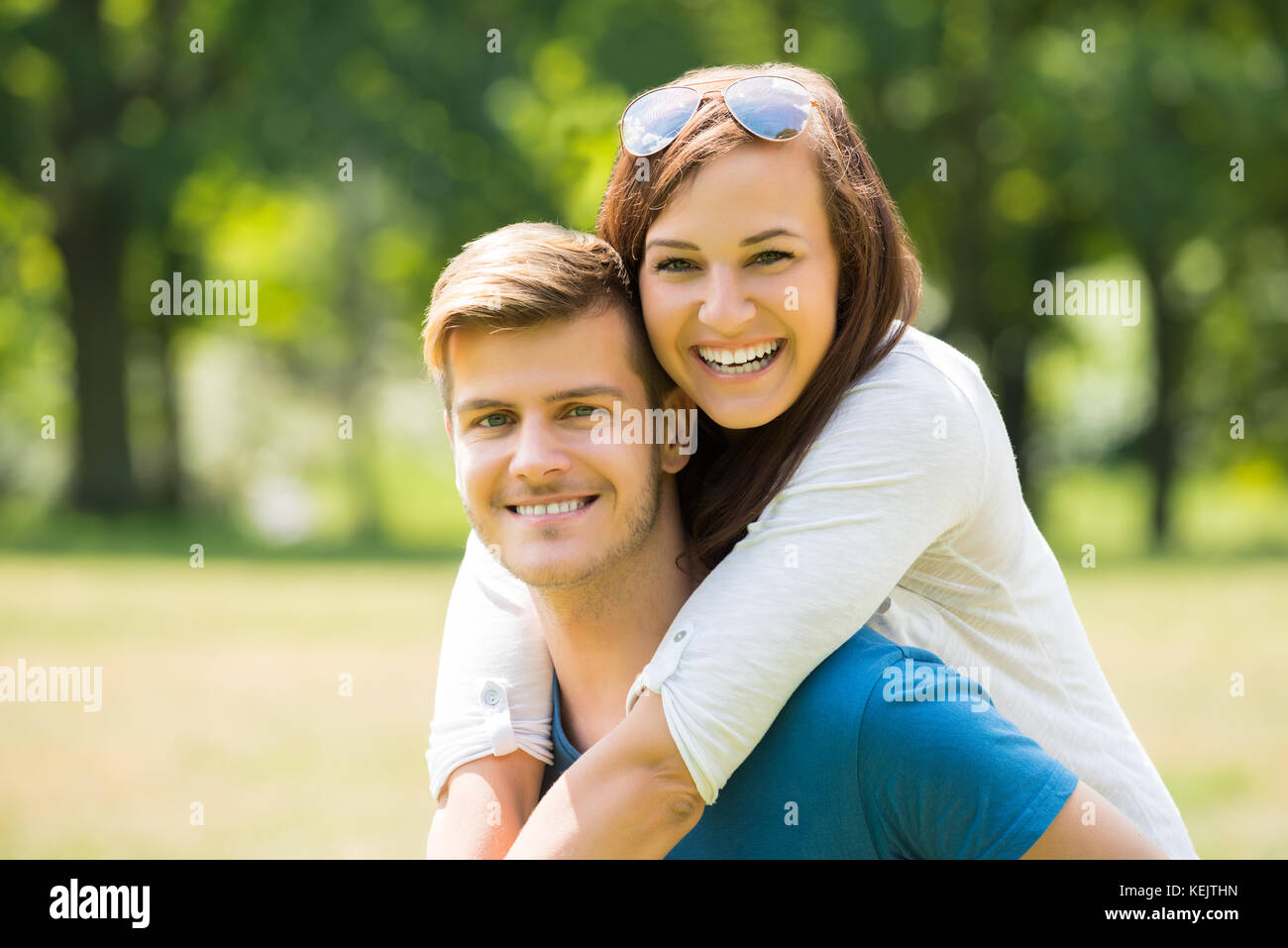 Retrato de mujer alegre y abrazando a su marido desde atrás Foto de stock