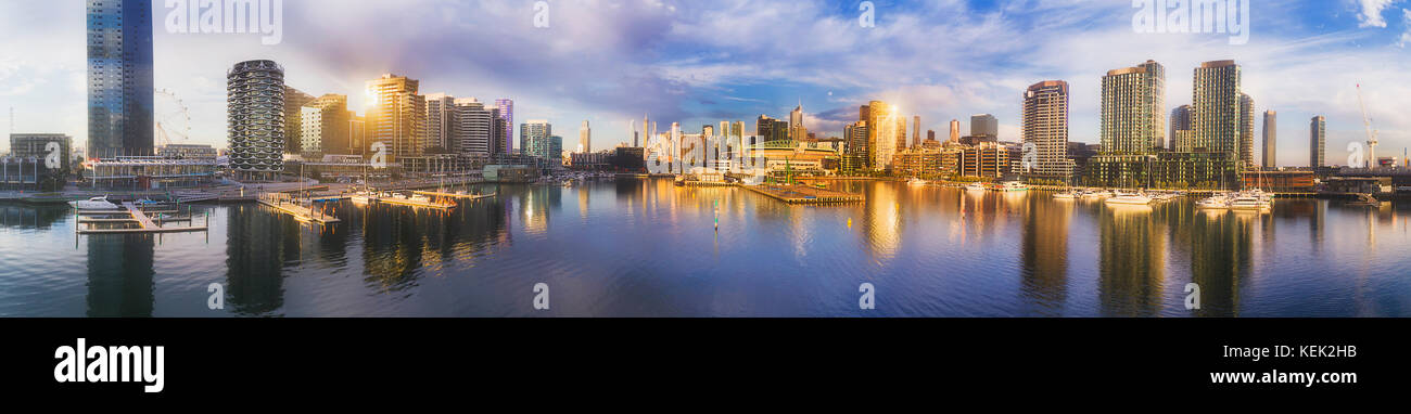 Suburbio de Melbourne Docklands todavía alrededor de la bahía de agua sobre el río Yarra con altos rascacielos torres residenciales y comerciales, reflejando un waterfront Foto de stock