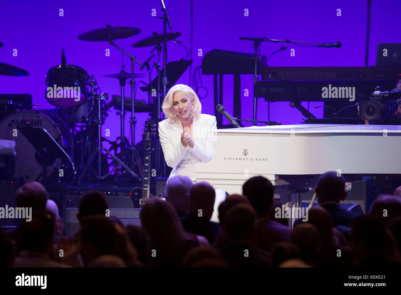 College Station, Texas, EE.UU. Octubre 21, 2017: la cantante Lady Gaga realiza en un piano de cola blanco en el escenario del concierto de una latina llamamiento y recaudación de fondos para los afectados por el huracán y tormenta de alivio. Ex presidentes de los Estados Unidos Jimmy Carter, George H.W. Bush, George W. Bush, Bill Clinton y Barack Obama fue el anfitrión del evento, celebrado en Reed Arena en el campus de la Universidad de Texas A&M University. Crédito: Bob Daemmrich/Alamy Live News Foto de stock