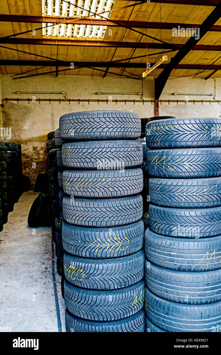 Montón de neumáticos viejos en una tienda Foto de stock