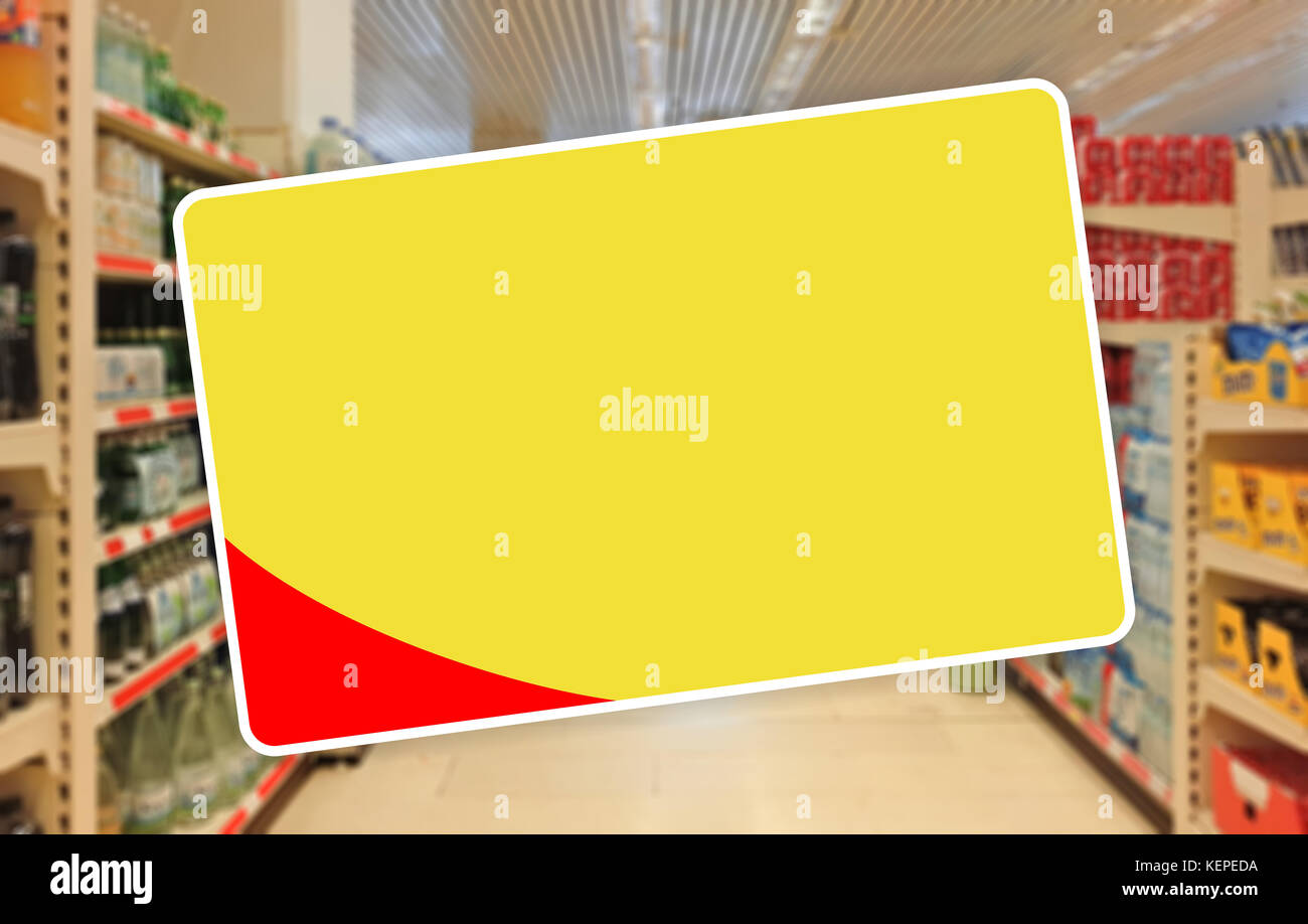 Etiqueta en blanco amarillo sobre un desenfoque de fondo de supermercados Foto de stock