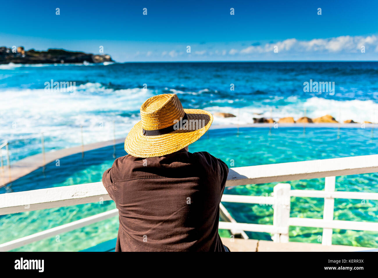 Un turista observa la impresionante costa, la piscina al aire libre y las vistas al mar a lo largo de la ruta costera entre Bondi Beach y Coogee Sydney Australia New South Wale Foto de stock