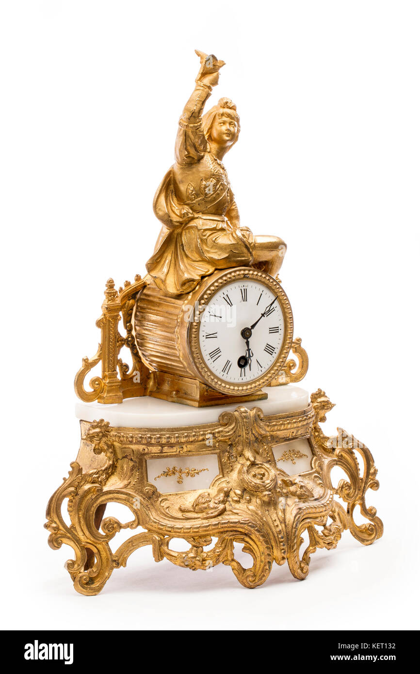 Antiguo reloj de mesa de color dorado con el fondo blanco. Foto de stock