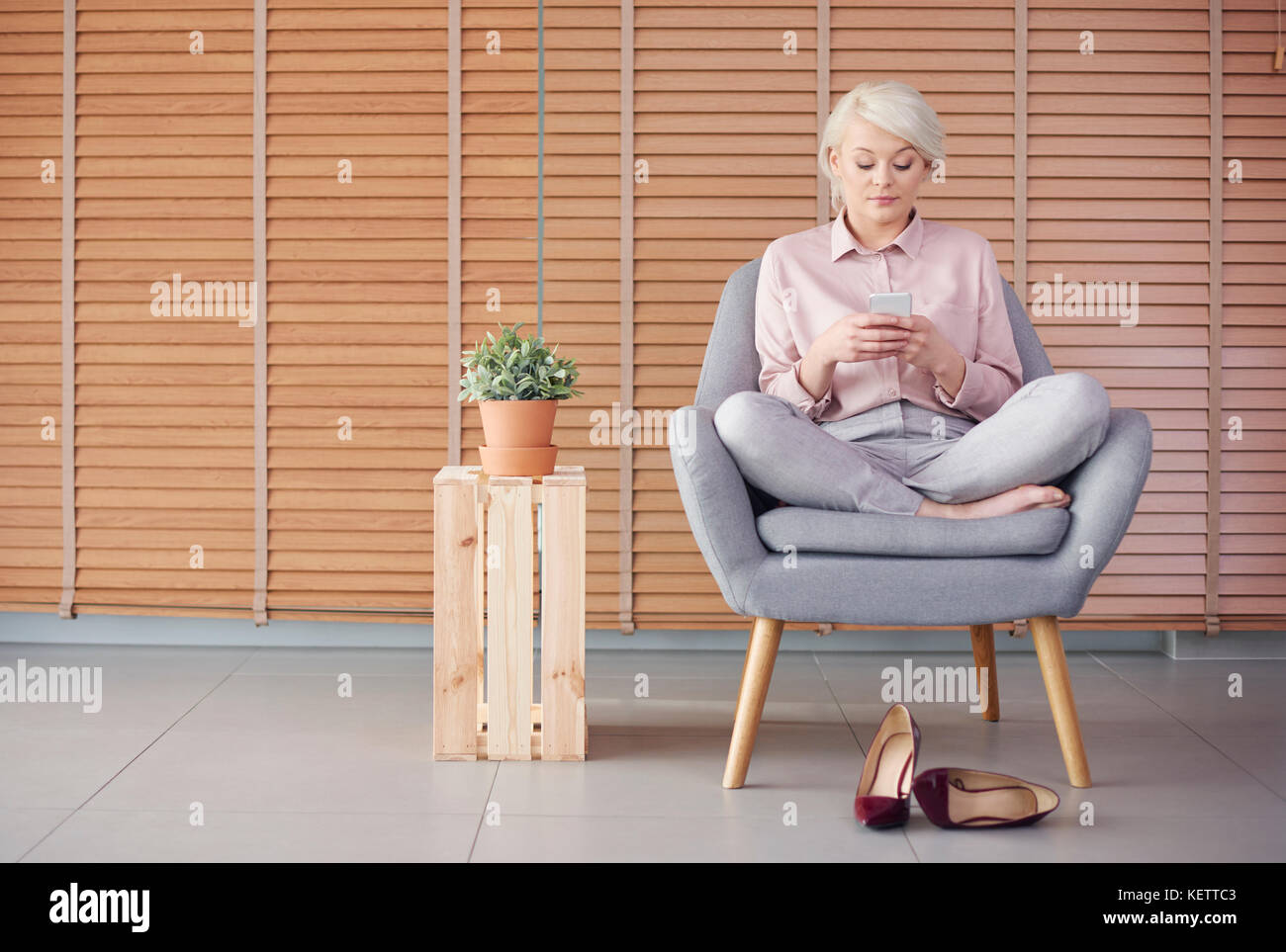 Mujer sentada inteligente sillón y leer un mensaje de texto Foto de stock