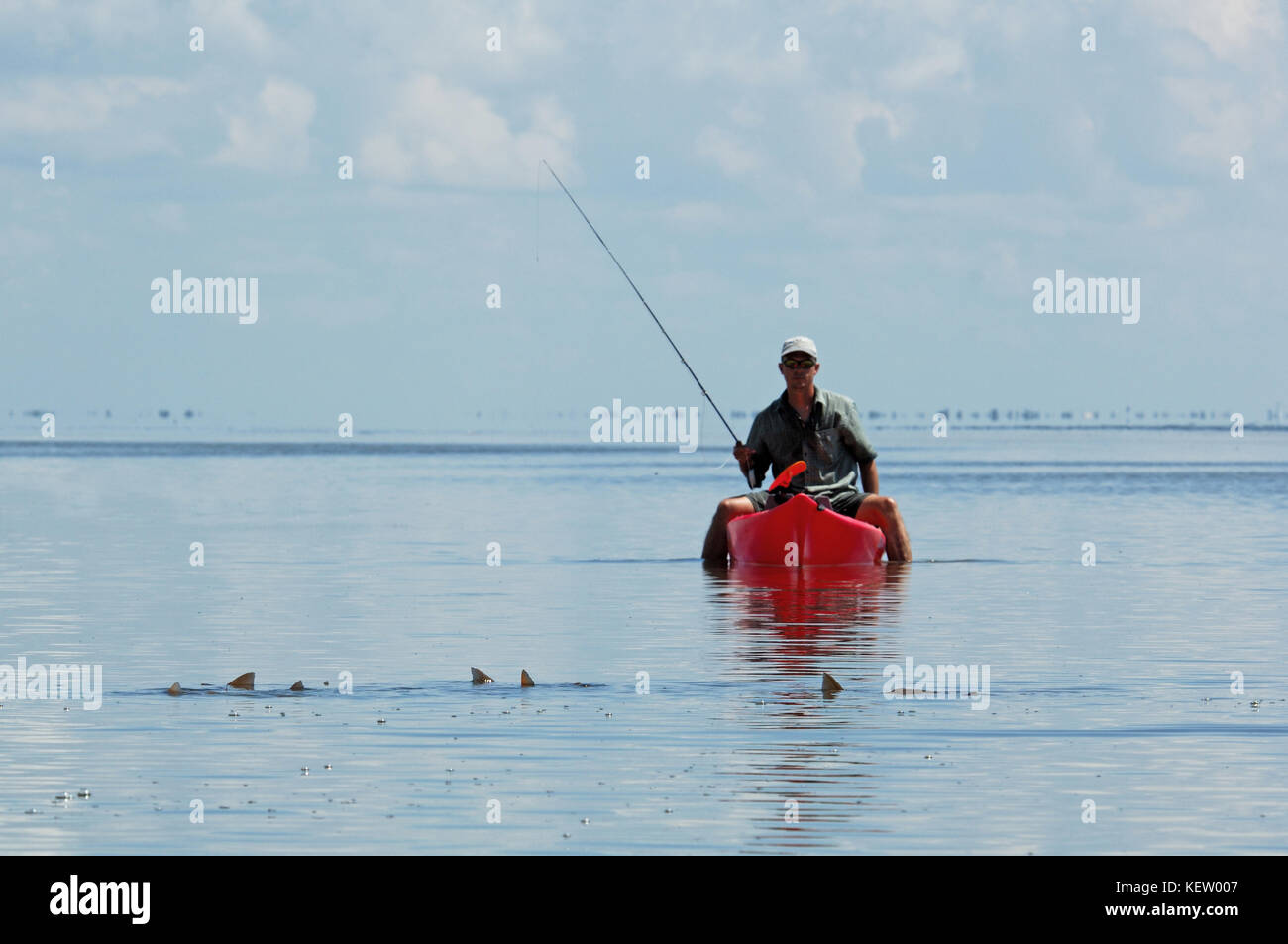 Un pescador con mosca la pesca de la gallineta o relaves tambor rojo desde un kayak en las poco profundas aguas de pisos cerca de Port Aransas, Texas Foto de stock