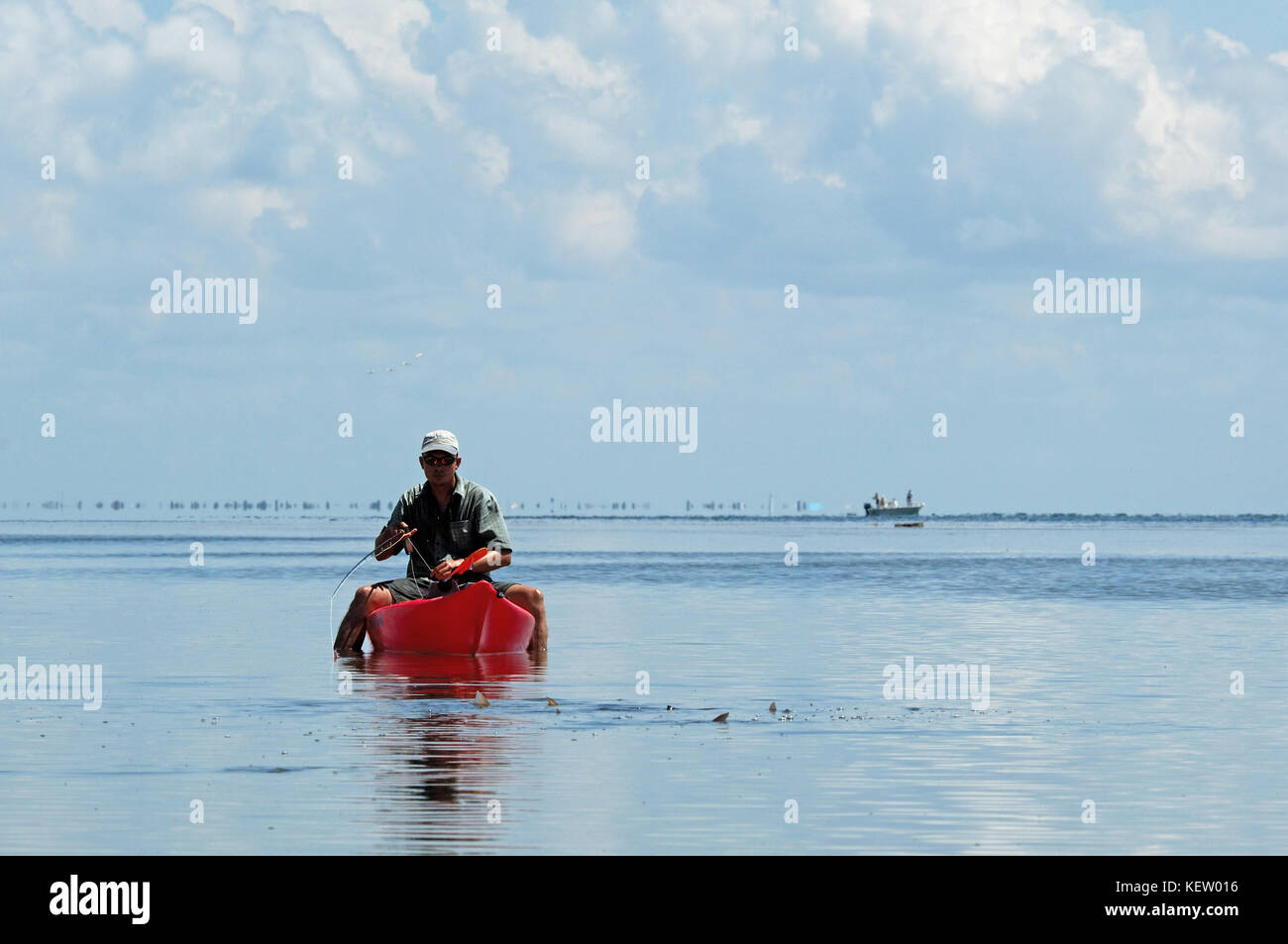 Un pescador con mosca la pesca de la gallineta o relaves tambor rojo desde un kayak en las poco profundas aguas de pisos cerca de Port Aransas, Texas Foto de stock