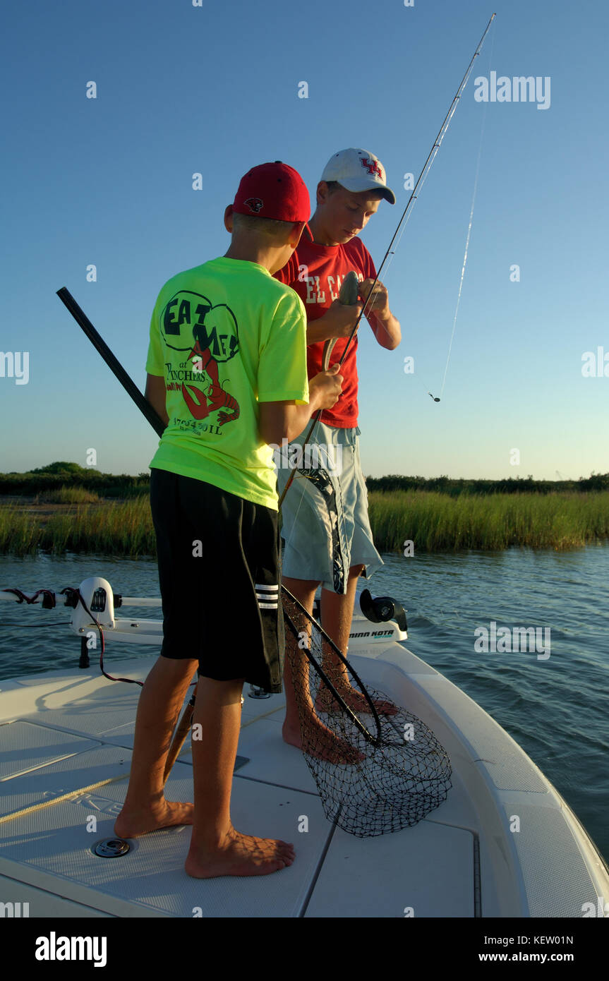 Los niños la pesca de la gallineta o tambor rojo en la bahía cerca de Port Aransas, Texas Foto de stock