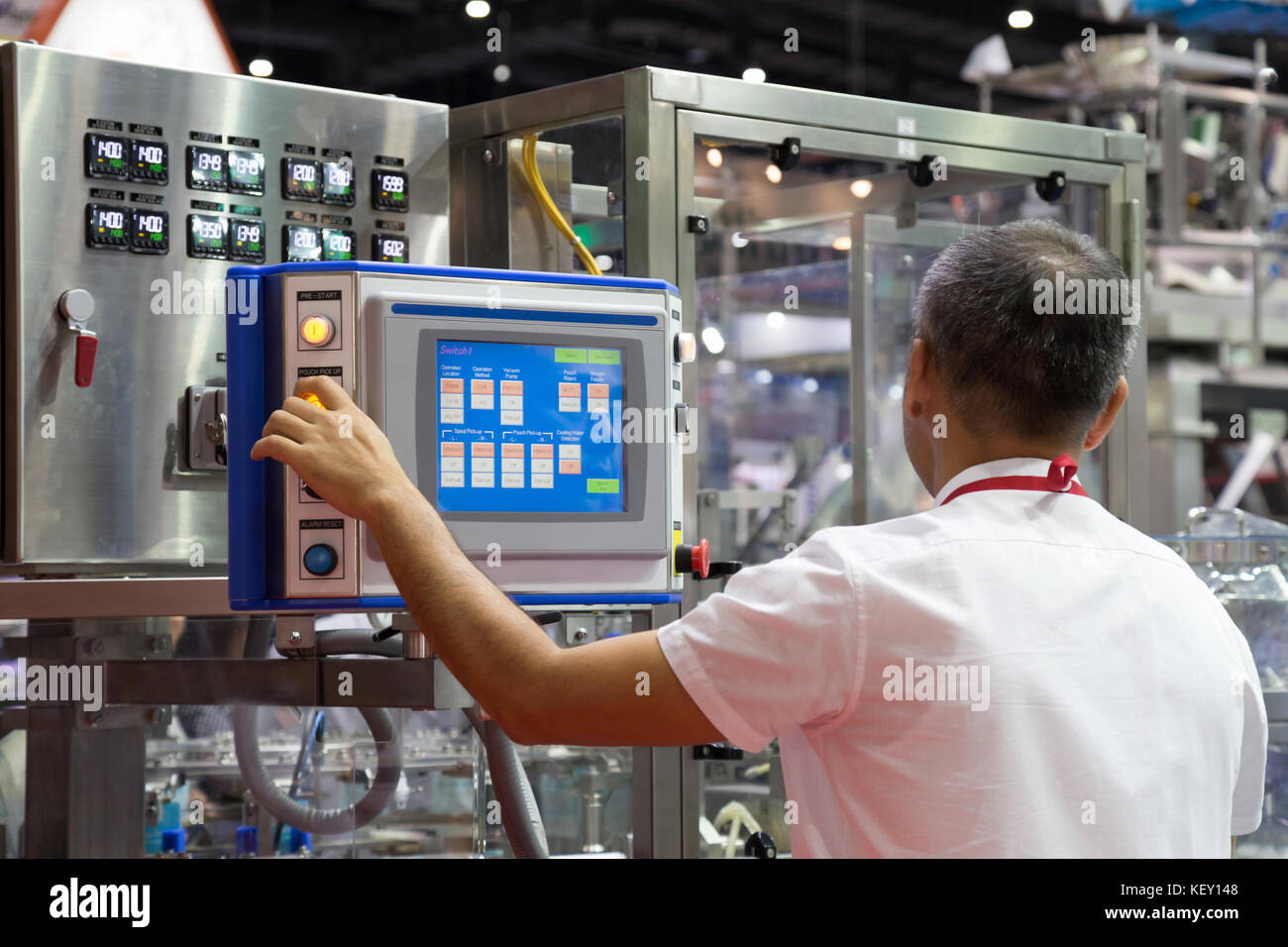 Ingeniero de fábrica control y pulsar el botón de tecnología importante en el panel de control de una máquina automática en la fabricación. Foto de stock