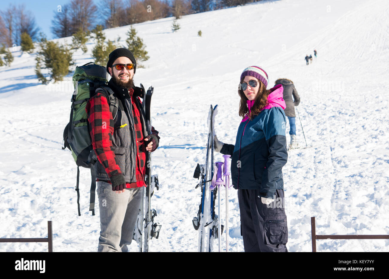 Pareja feliz con equipo para esquiar en la montaña nevada Foto de stock