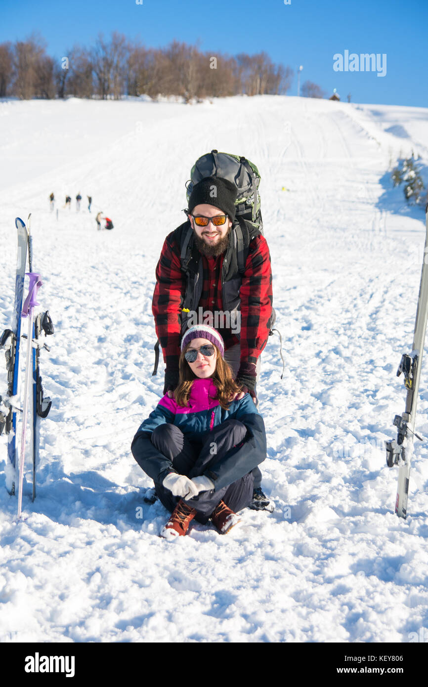 Pareja feliz con equipo para esquiar en la montaña nevada Foto de stock