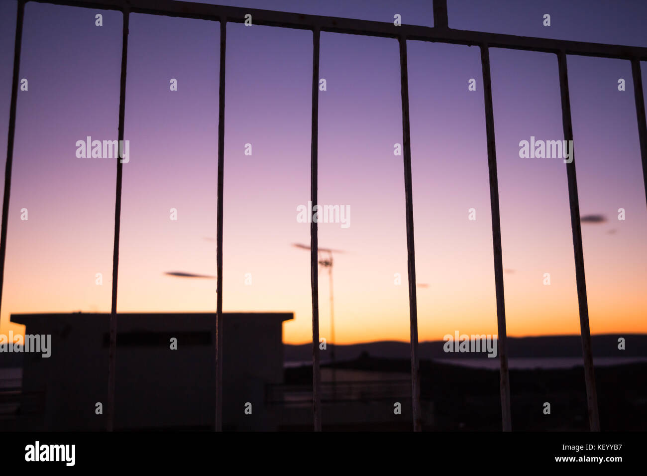 Vívido y colorido Amanecer/Atardecer cielo visto detrás de las rejas. Foto de stock
