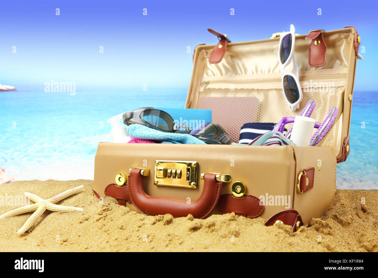 Full maleta abierta sobre fondo playa tropical Fotografía de stock - Alamy
