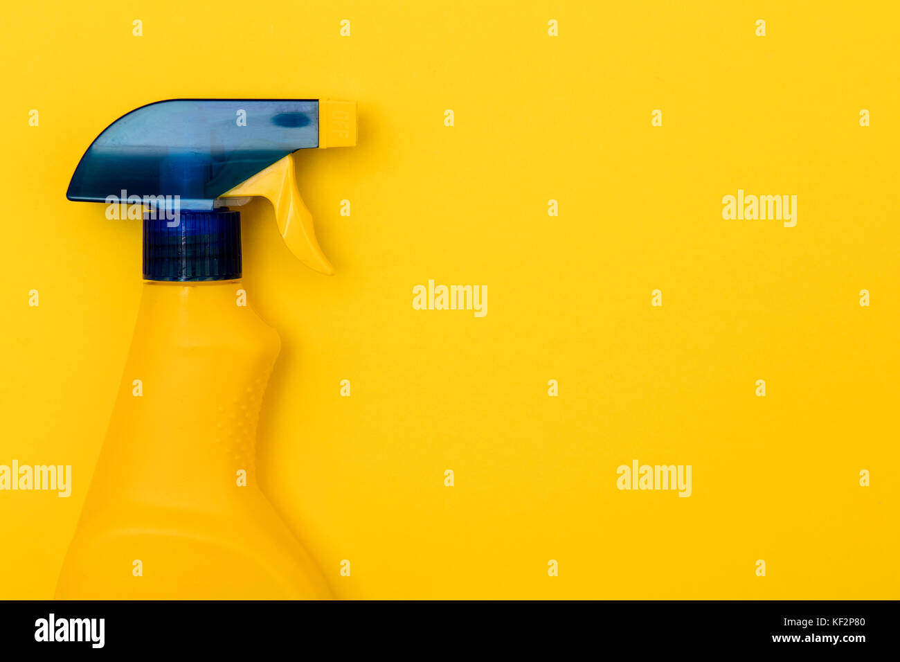 Botella de spray limpiador de productos sobre un fondo de color amarillo brillante Foto de stock
