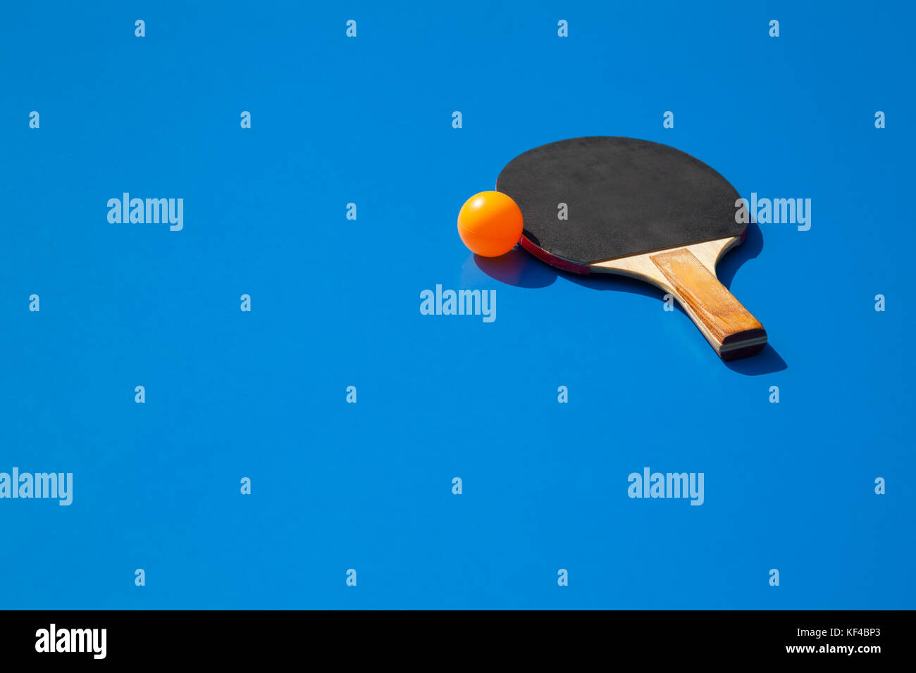 Naranja con Paleta pelota de ping-pong en una mesa de tenis azul Fotografía  de stock - Alamy