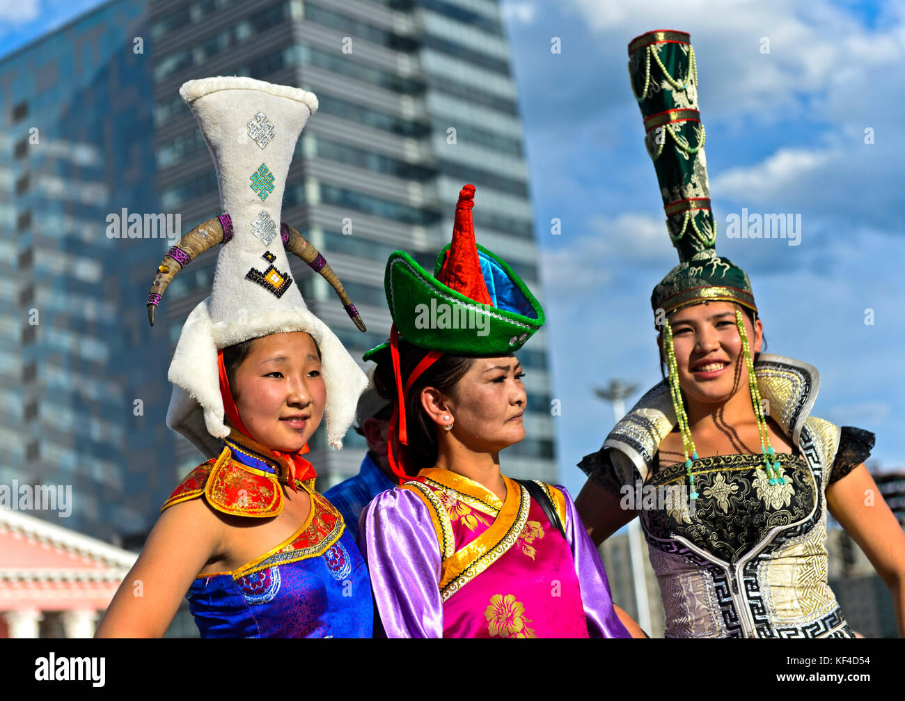 Thre jóvenes vestidas con sombreros extravagantes en el traje nacional de Mongolia, Ulaanbaatar, Mongolia festival Foto de stock