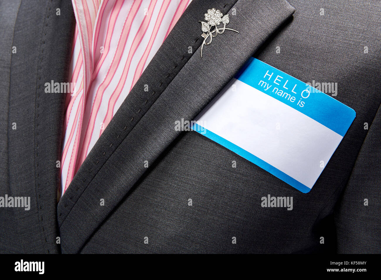 Mujer vistiendo traje negro y camisa a rayas rosa y blanco y plata elegante  polo mientras vestían en blanco Fotografía de stock - Alamy