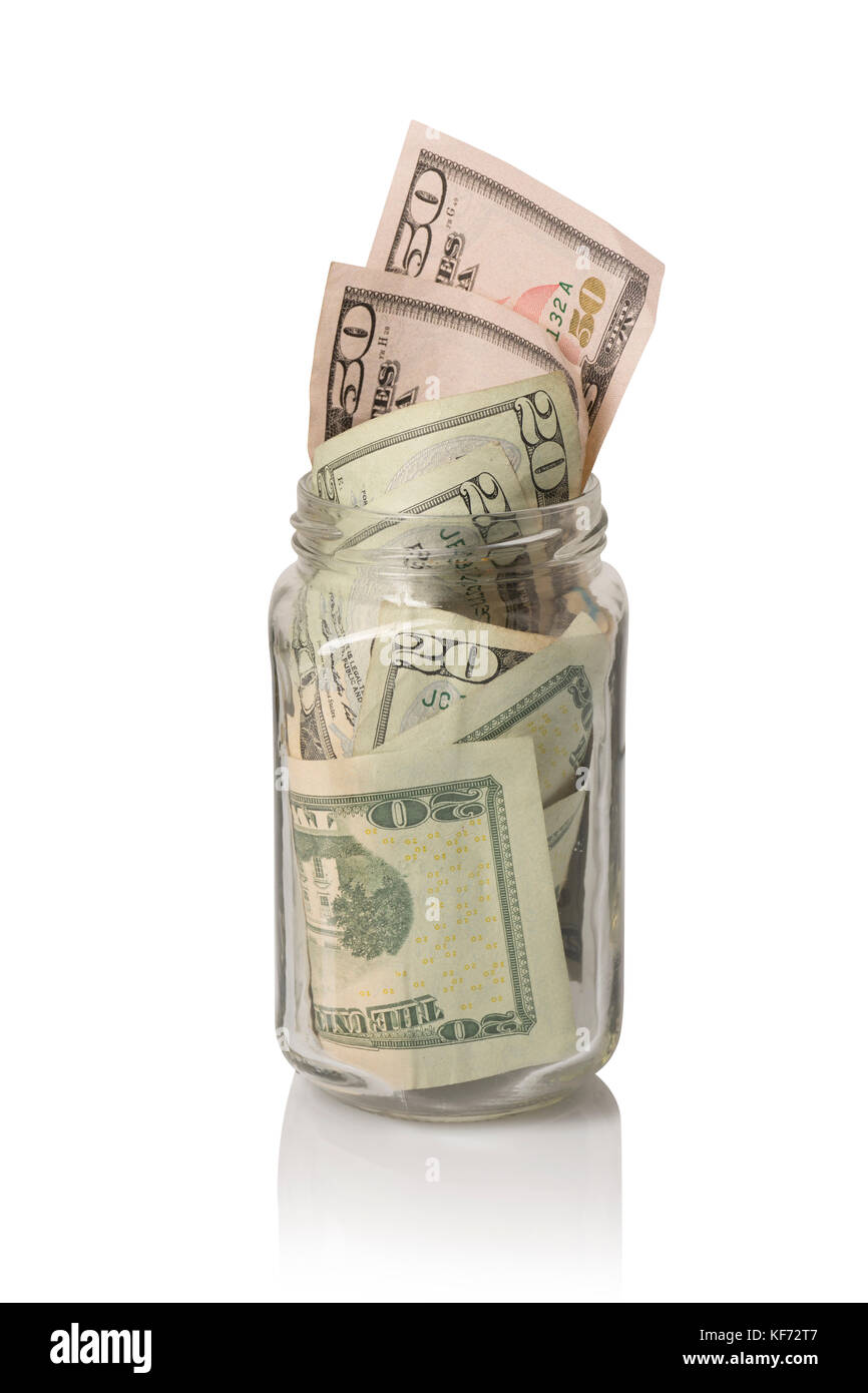 Un vaso pequeño tip jar jar o donación rellenas con american cincuenta y veinte dólares, sobre blanco con reflexión Foto de stock