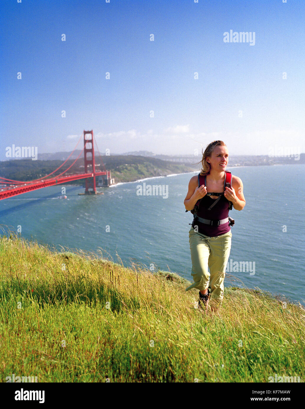 California, Estados Unidos, Marin, mujer senderismo por encima del puente Golden Gate, con san francisco en la distancia Foto de stock