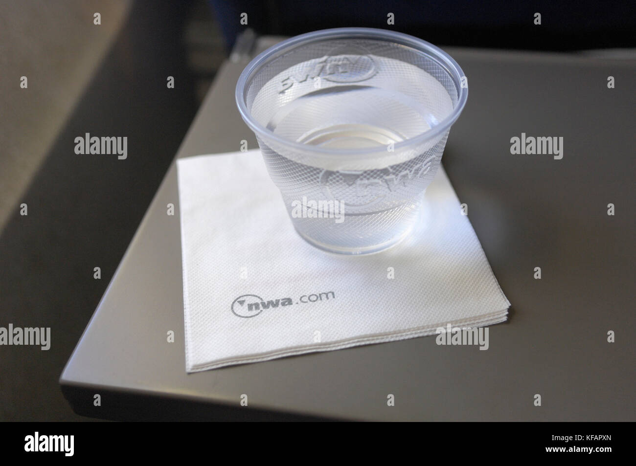 Un vaso de plástico de agua potable y una servilleta de papel en la cabina  de clase económica en un Boeing 757-200 de Northwest Airlines enroute  MAR-MSP-número de vuelo NW1 Fotografía de