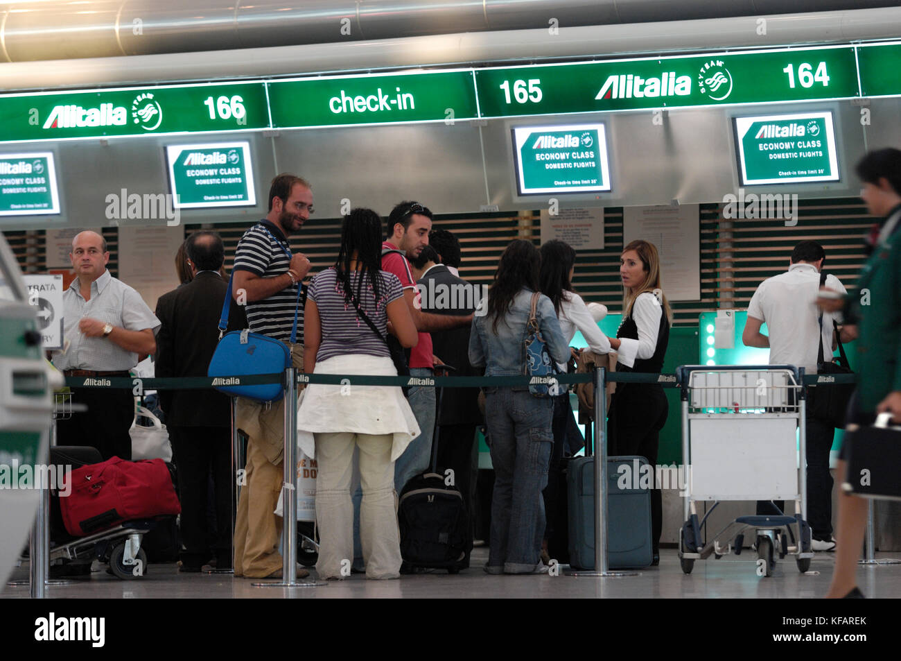 bolsillo Disipar contrabando Los pasajeros con equipaje en los mostradores de check-in de Alitalia en el  terminal Fotografía de stock - Alamy