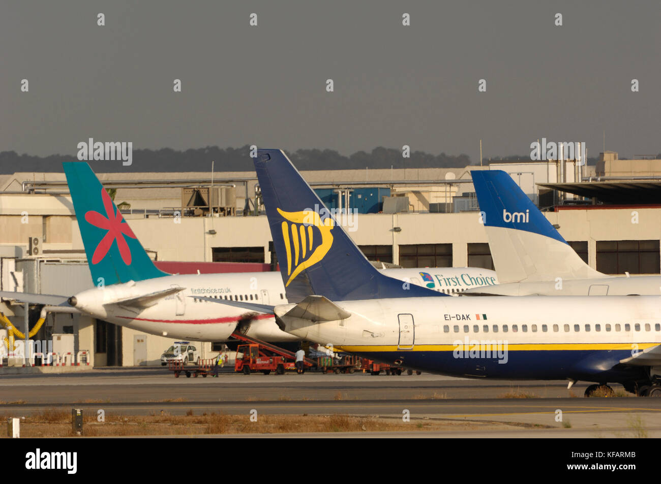 Las aletas de cola de Ryanair Boeing 737-800 con First Choice Airways 757-200 y bmi British Midland International Airbus A320-200 estacionados en la terminal beh Foto de stock