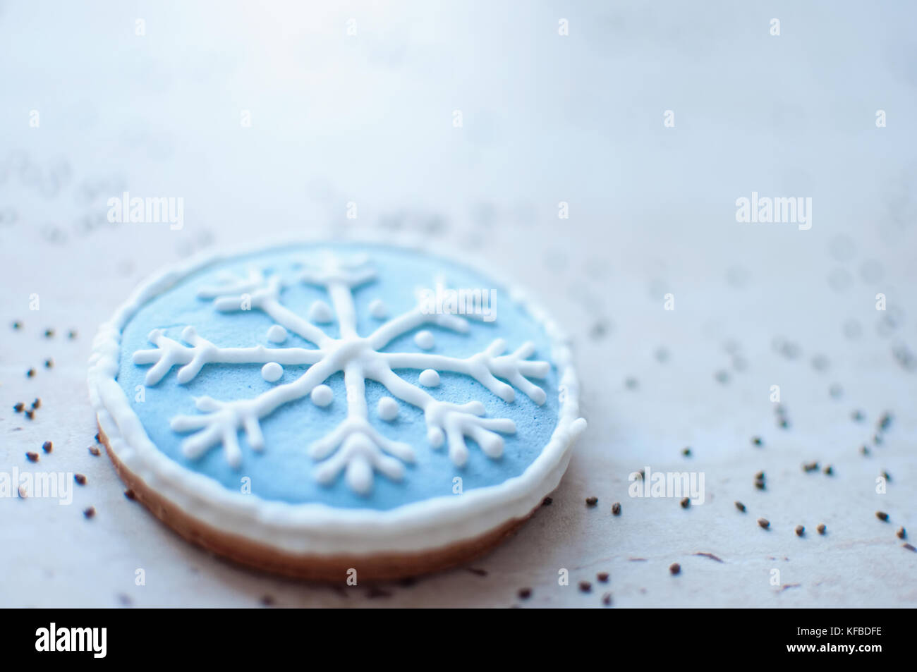 Una galleta de jengibre de navidad en la forma de un copo de nieve redonda azul cerca. El enfoque selectivo, bokeh. Foto de stock