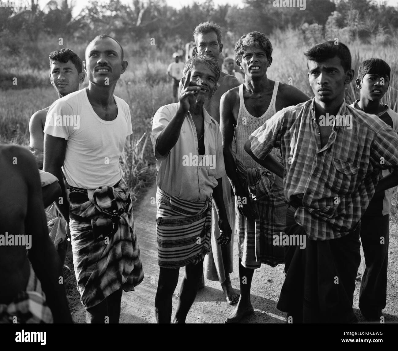 SRI LANKA, en Asia, un grupo de aldeanos locales mirando hacia arriba (B&W) Foto de stock
