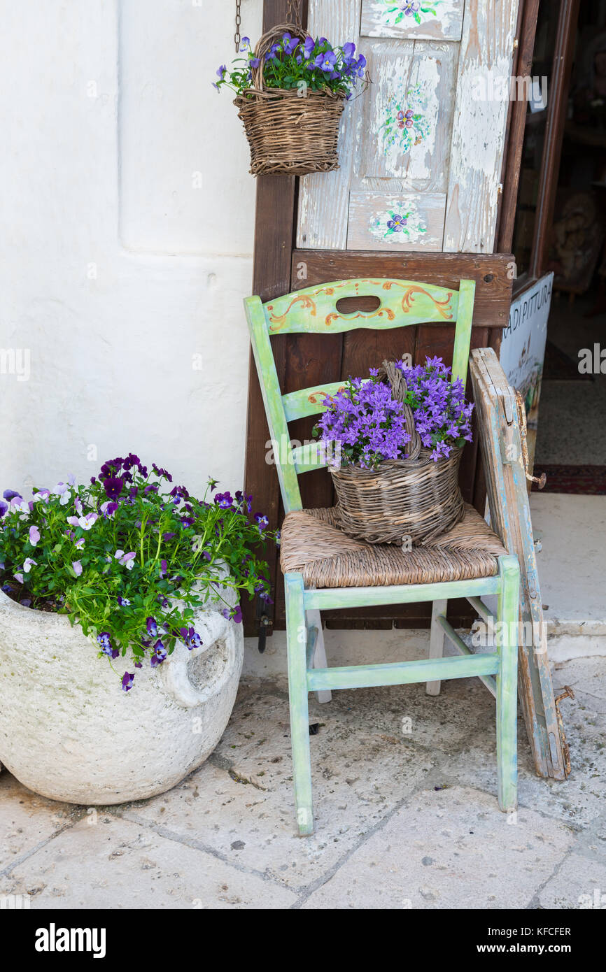 Locorotondo (Puglia, Italia) - vista del pintoresco pueblecito en el sur de Italia; el detalle de las paredes y puertas con sus coloridas flores. Foto de stock