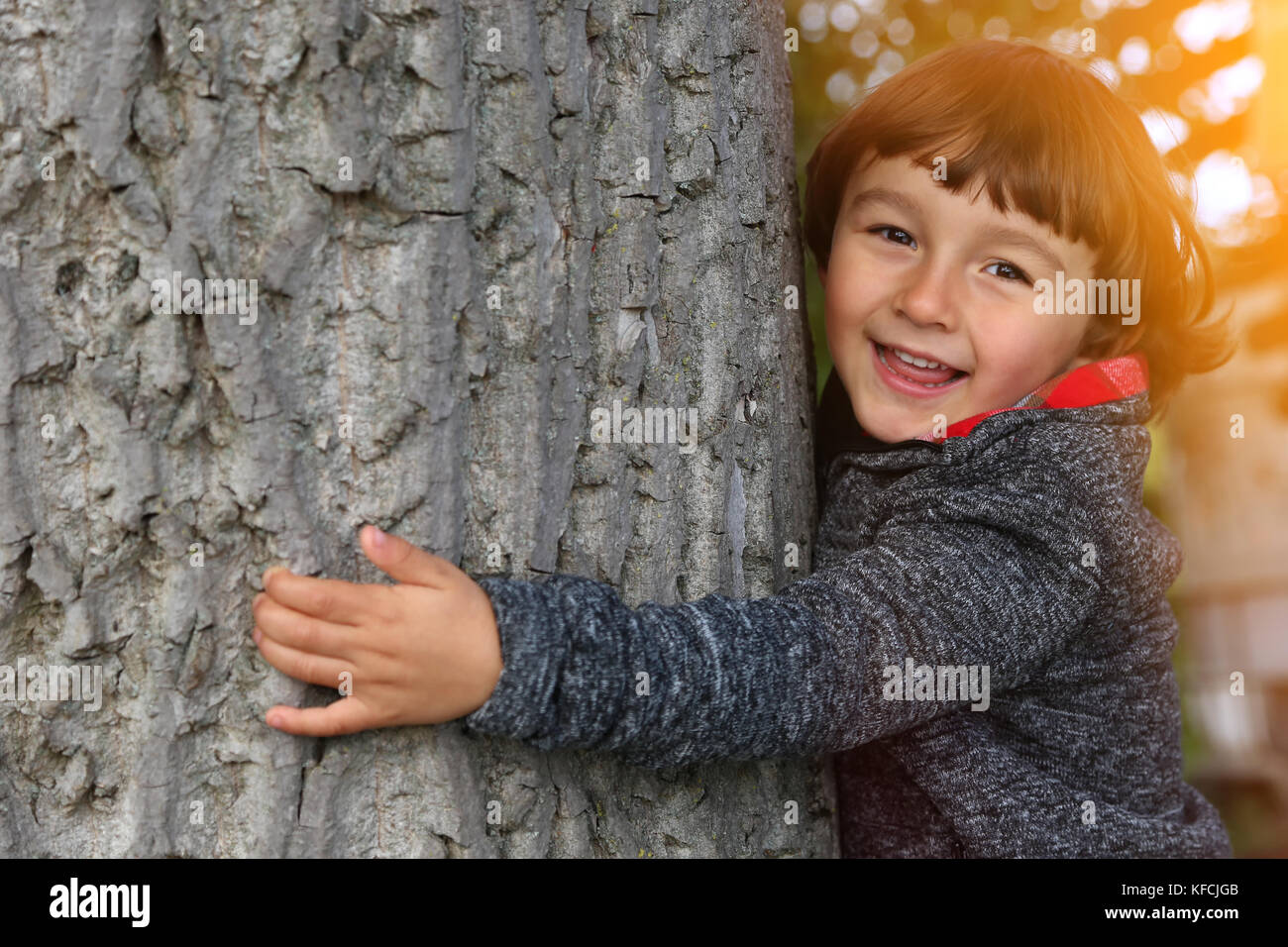 Chico abrazando árboles protección ambiental para la conservación de la naturaleza al aire libre en el exterior Foto de stock