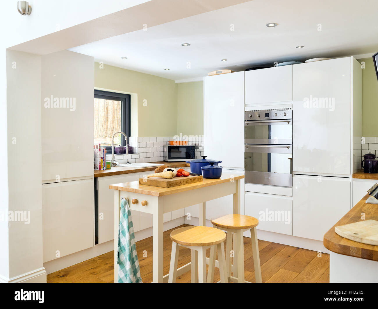 Un contemporáneo, crema, satinado, flush fachada cocina de diseñador en una casa en el Reino Unido. Foto de stock