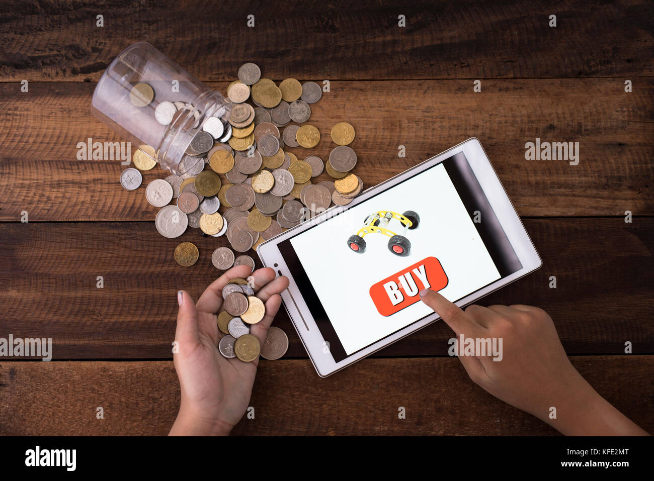Concepto de compras online - boy comprar juguetes online utilizando digital  tablet con monedas y fondo de madera Fotografía de stock - Alamy