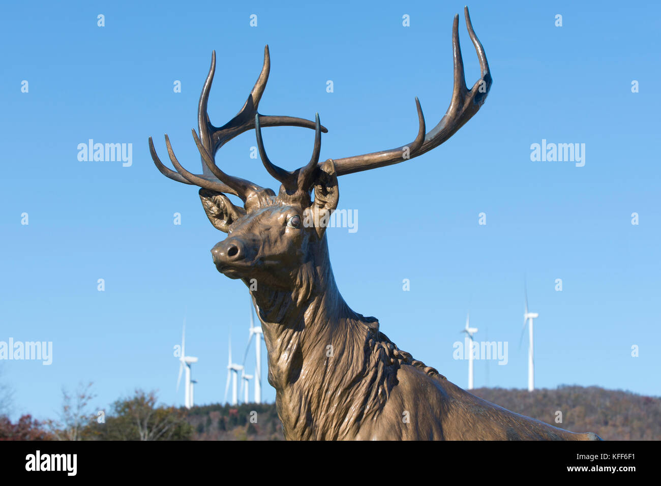 Estatua de un ciervo macho (buck) con aerogeneradores en el fondo en el oeste, Massachusetts, EE.UU. Foto de stock