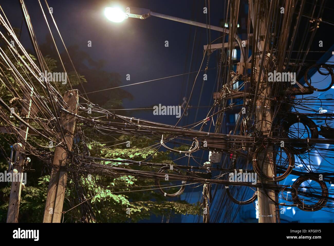 Maraña de cables en la ciudad capital durante la noche. cables enredados peligroso, puede provocar un cortocircuito. Foto de stock